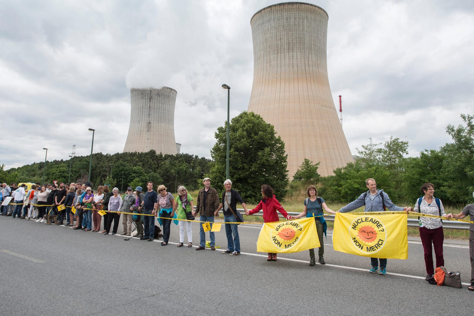 Teilnehmer bilden vor dem Atomkraftwerk Tihange (Belgien) bei der Protestaktion "Kettenreaktion" gegen belgische Atommeiler eine Menschenkette.