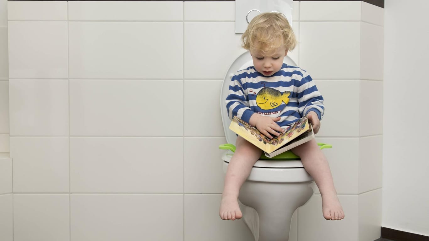 Kind sitzt auf der Toilette: Blähungen sollten Kinder nicht in aller Öffentlichkeit ausleben.