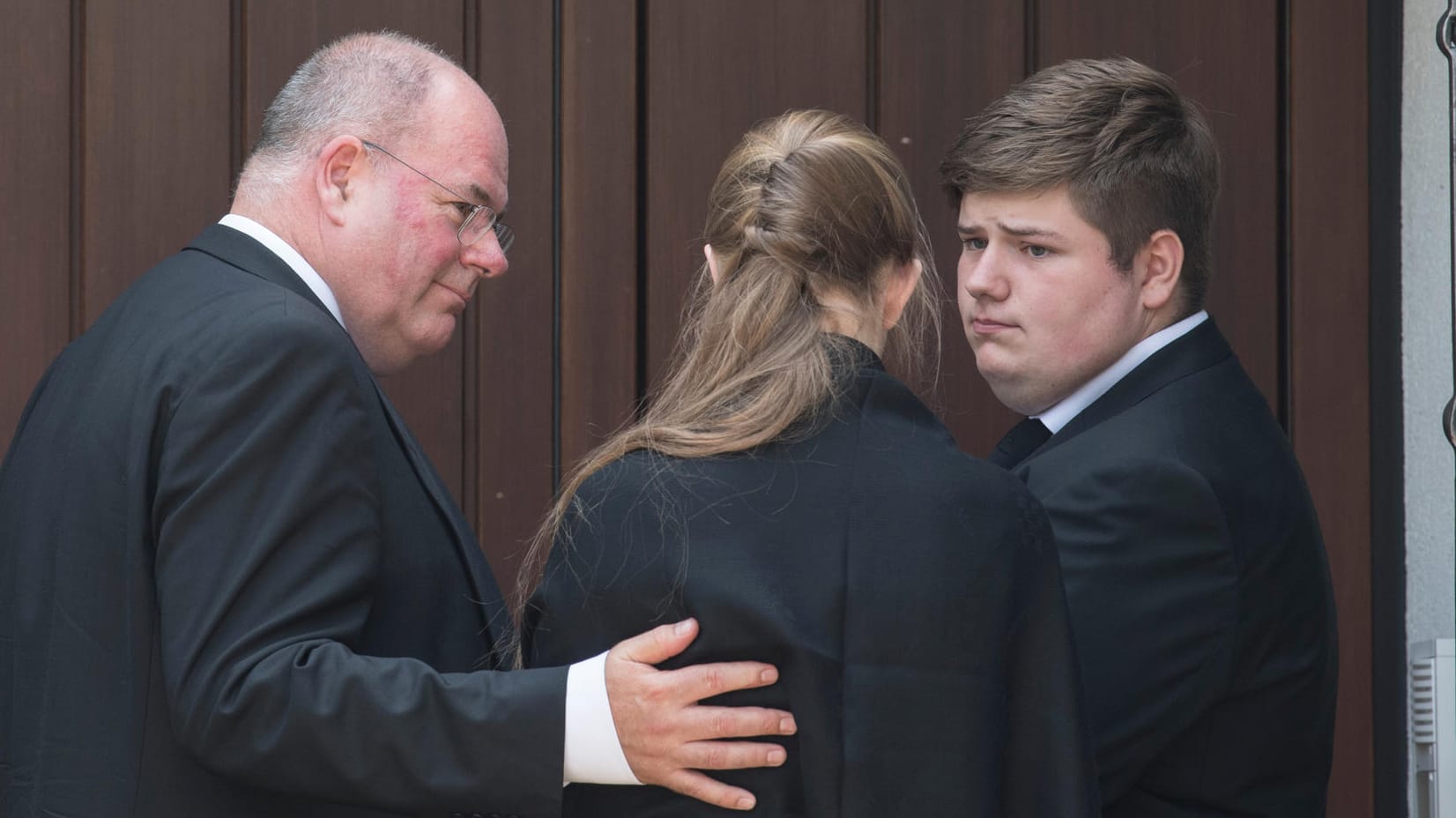 Walter Kohl und zwei Enkelkinder des verstorbenen Altkanzlers stehen am Wohnhaus Kohls in Oggersheim vor verschlossenen Türen.