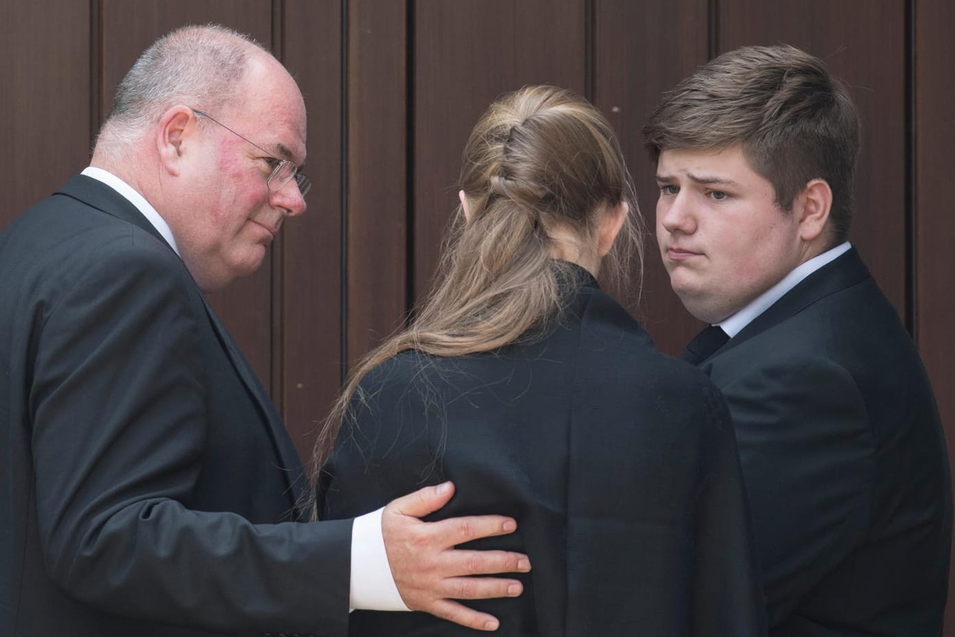 Walter Kohl und zwei Enkelkinder des verstorbenen Altkanzlers stehen am Wohnhaus Kohls in Oggersheim vor verschlossenen Türen.