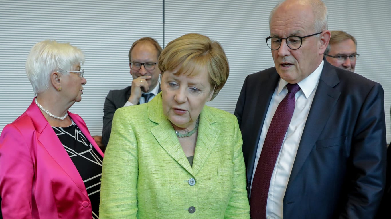 Bundeskanzlerin Angela Merkel spricht zu Beginn der Unions-Fraktionssitzung im Bundestag mit der CSU-Landesgruppenchefin Gerda Hasselfeldt (l) und Unions-Fraktionschef Volker Kauder.