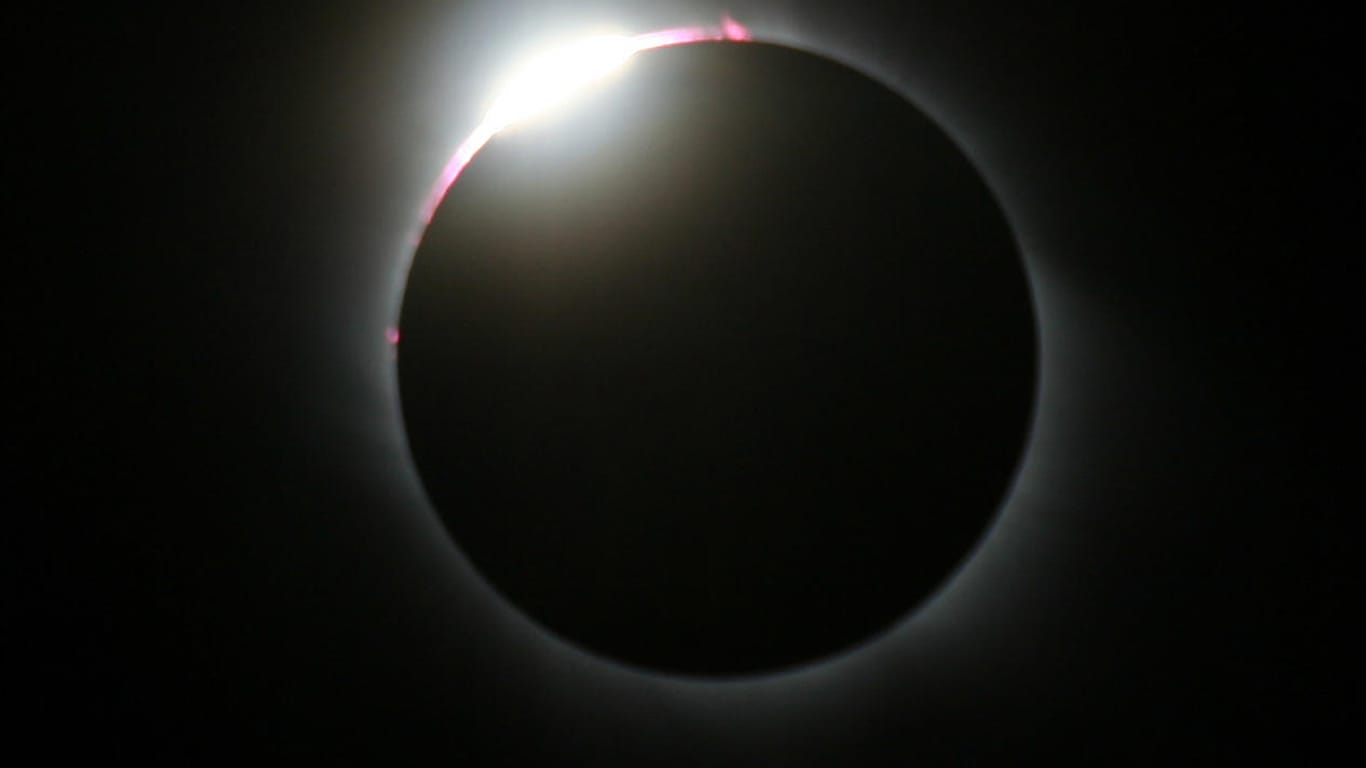 Eine totale Sonnenfinsternis tritt ein, wenn der Mond die Sonne komplett verdeckt und sein Kernschatten auf die Erde fällt.
