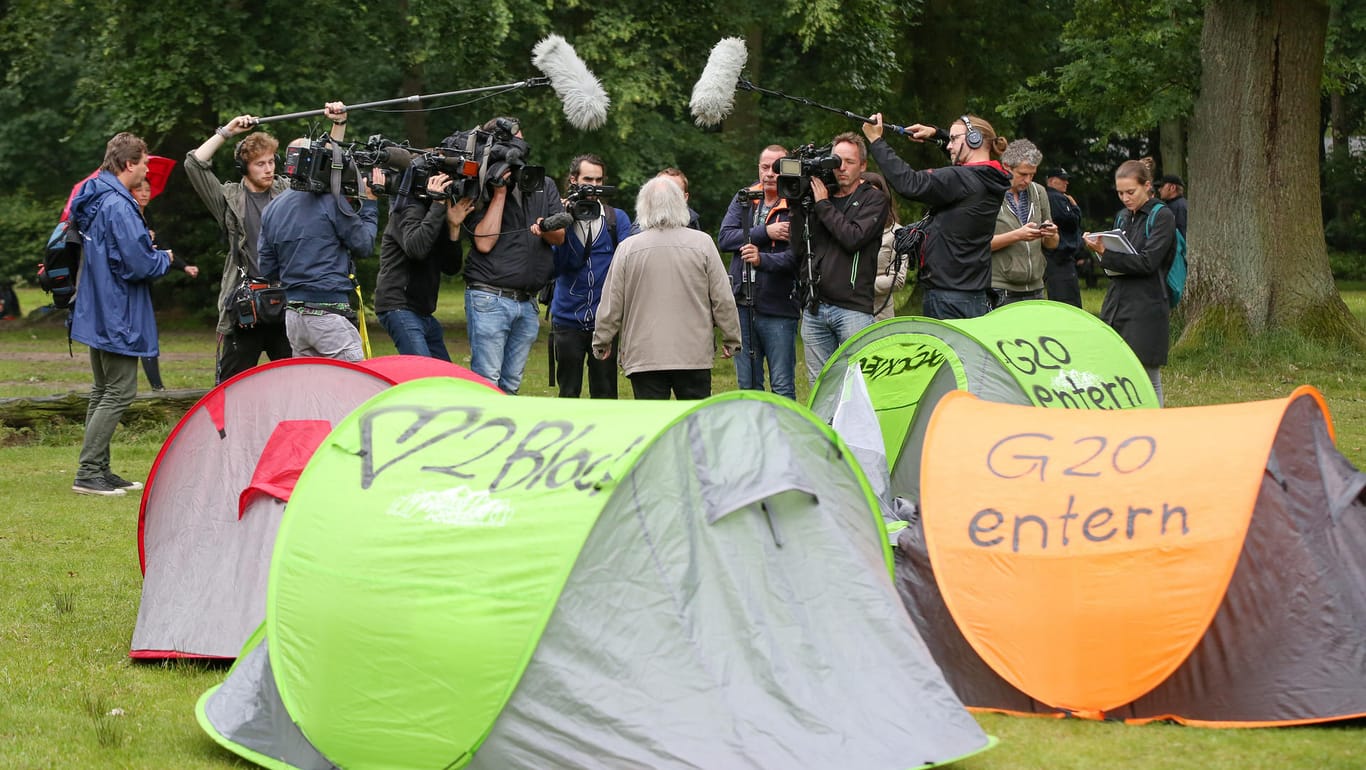 Journalisten stehen um den Linke-Politiker Robert Jarowoy (Mitte) bei einer Protestaktion am Mittwoch im Volkspark Altona in Hamburg.