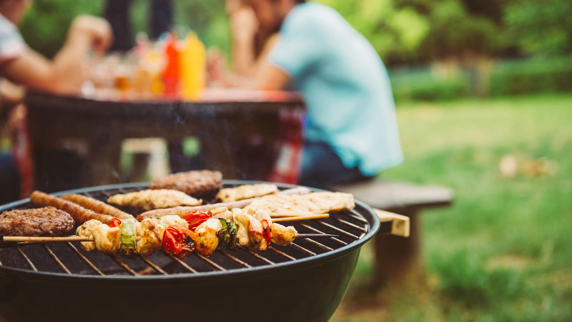 Ein paar Freunde grillen im Park.