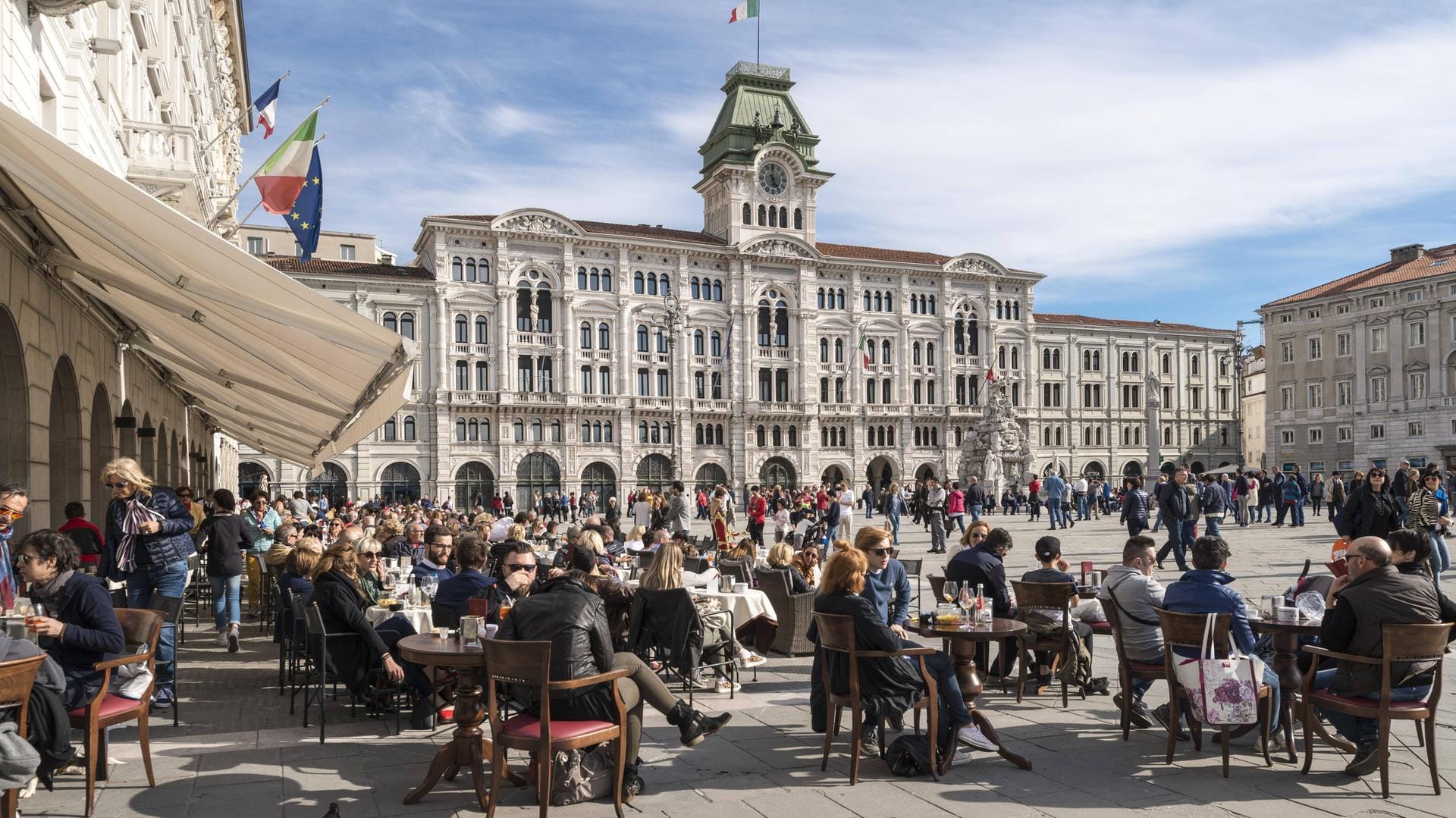 Zahlreiche Besucher genießen ihren Espresso und Caffè am Piazza dell'Unita d'Italia in Triest (Italien).