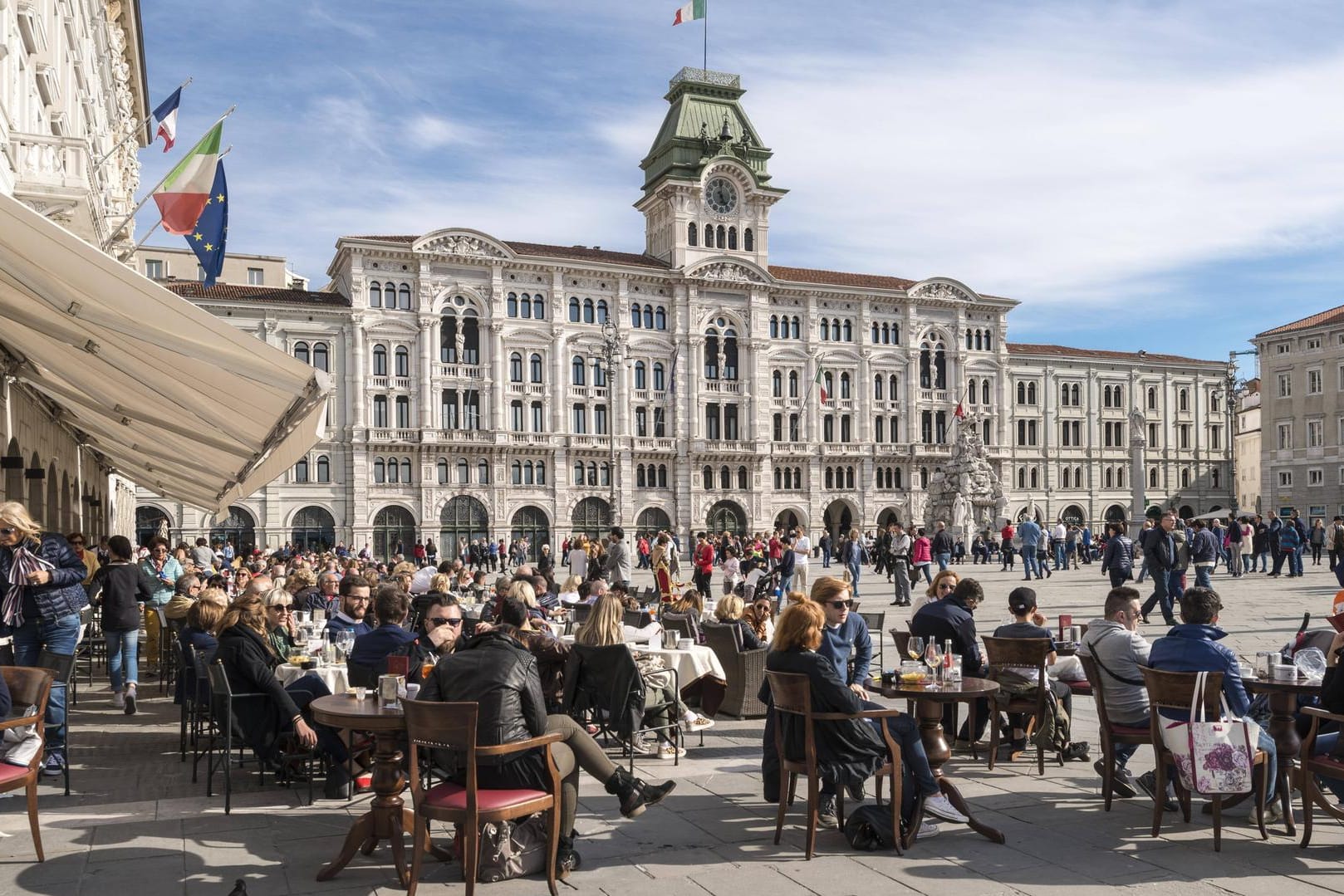 Zahlreiche Besucher genießen ihren Espresso und Caffè am Piazza dell'Unita d'Italia in Triest (Italien).