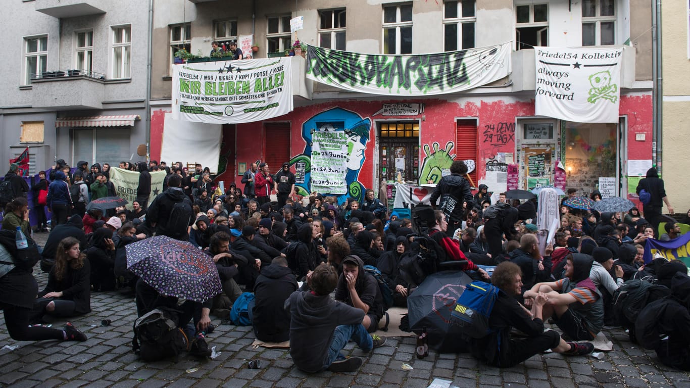 Demonstranten sitzen auf der Straße vor dem Haus Nr. 54 in der Friedelstraße in Berlin-Neukölln.