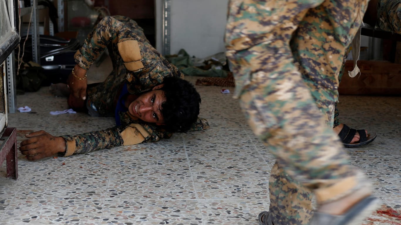 Ein Kämpfer der Syrischen Demokratischen Streitkräfte (SDF) liegt nach einem Mörser-Angriff des IS in Rakka verletzt am Boden.