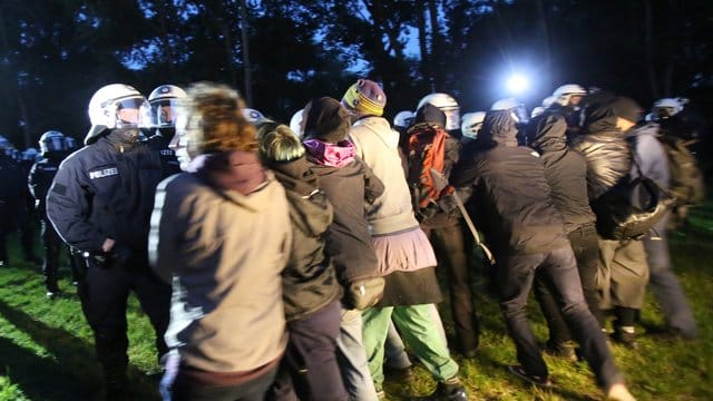 Polizisten rangeln mit Campteilnehmern.