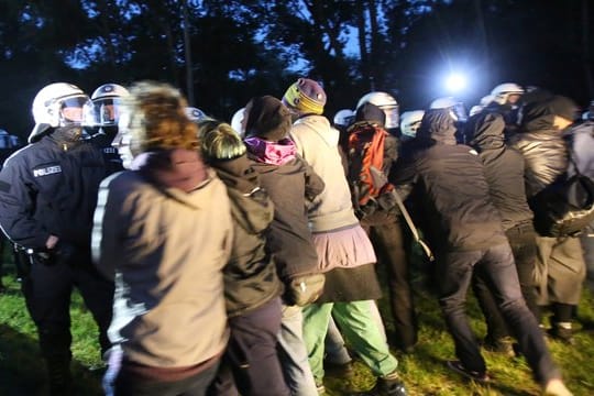 Polizisten rangeln mit Campteilnehmern.