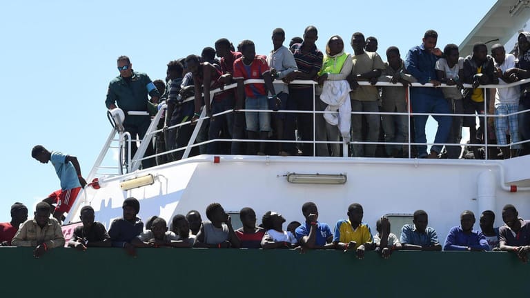 Migranten stehen am Deck des spanischen Schiffes «Rio Segura». Über 1200 Migranten, darunter Kinder, wurden aus dem Mittelmeer gerettet. Italien hatte gedroht, Schiffe mit geretteten Migranten vor den Häfen abzuweisen, wenn es nicht mehr Unterstützung durch die EU gebe.