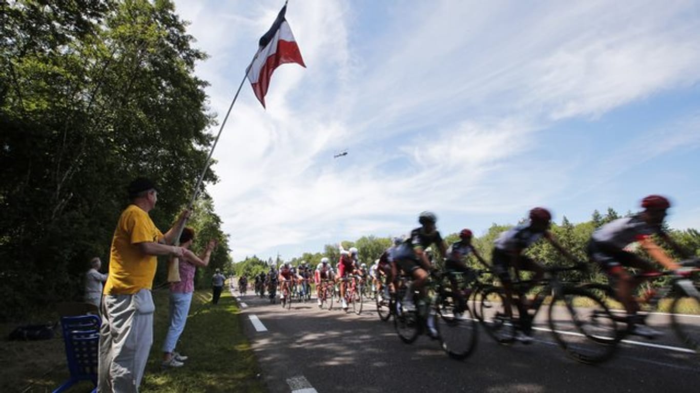 Zuschauer jubeln bei der Tour de France dem vorbeifahrenden Hauptfeld zu.
