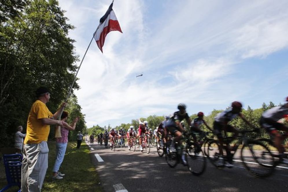 Zuschauer jubeln bei der Tour de France dem vorbeifahrenden Hauptfeld zu.