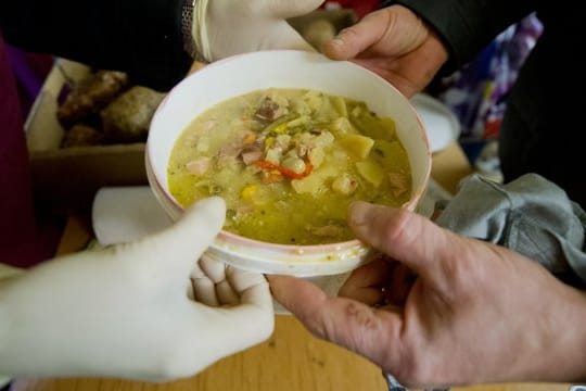 Eine warme Suppe wird an Bedürftige in einer Kirchengemeinde ausgegeben.