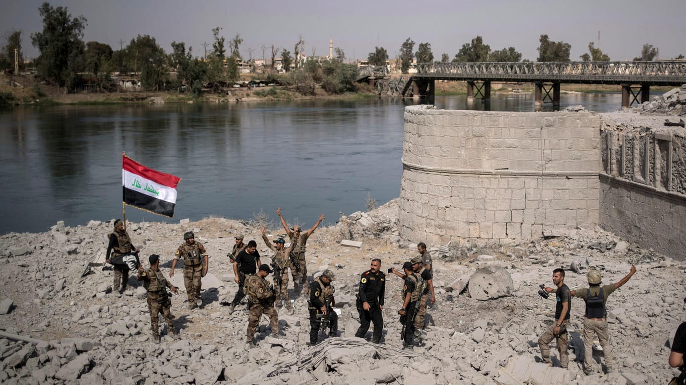 Irakische Spezialeinheiten feiern in Mossul am Ufer des Tigris den Sieg über die IS-Anhänger, während in anderen Teilen Mossuls noch gekämpft wird.