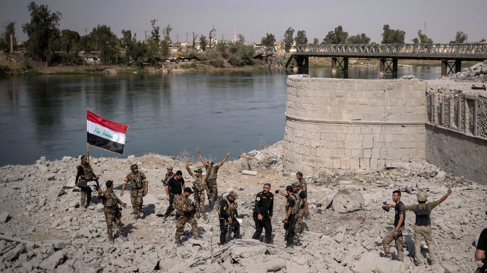 Irakische Spezialeinheiten feiern in Mossul am Ufer des Tigris den Sieg über die IS-Anhänger, während in anderen Teilen Mossuls noch gekämpft wird. Irakische Spezialeinheiten feiern in Mossul am Ufer des Tigris den Sieg über die IS-Anhänger, während in anderen Teilen Mossuls noch gekämpft wird.