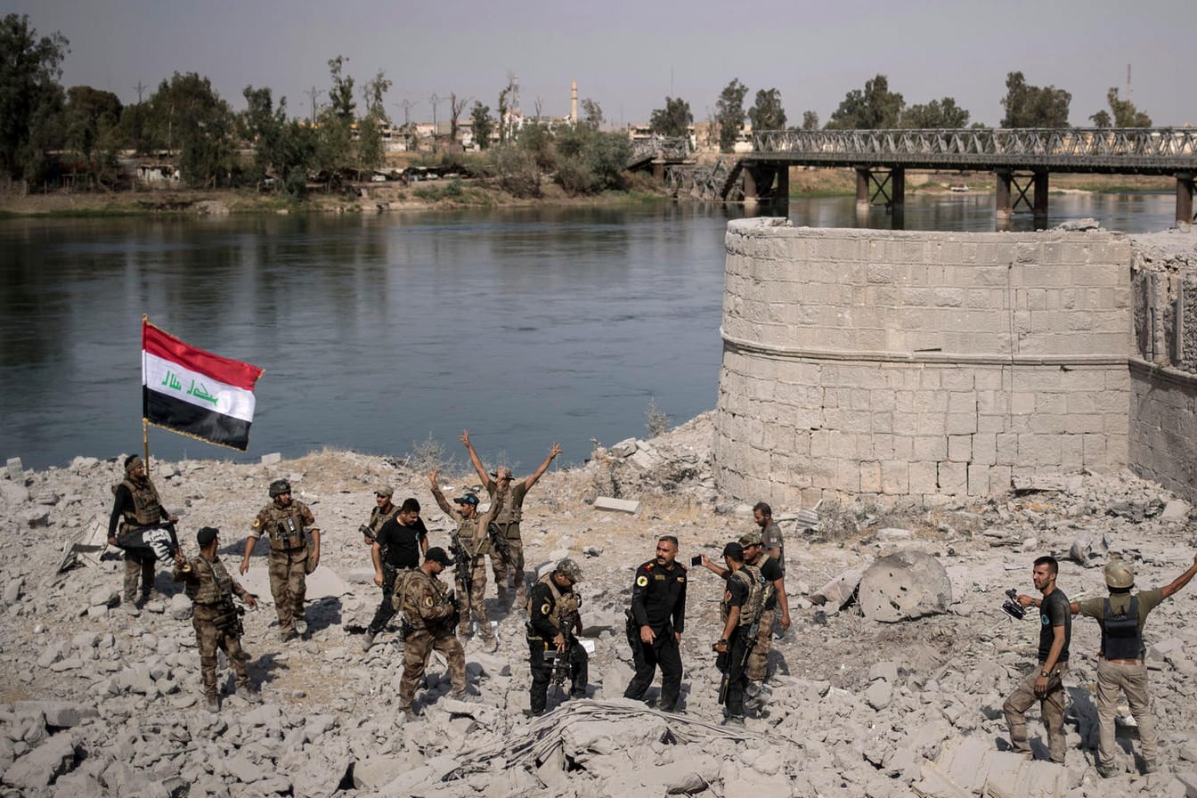 Irakische Spezialeinheiten feiern in Mossul am Ufer des Tigris den Sieg über die IS-Anhänger, während in anderen Teilen Mossuls noch gekämpft wird.