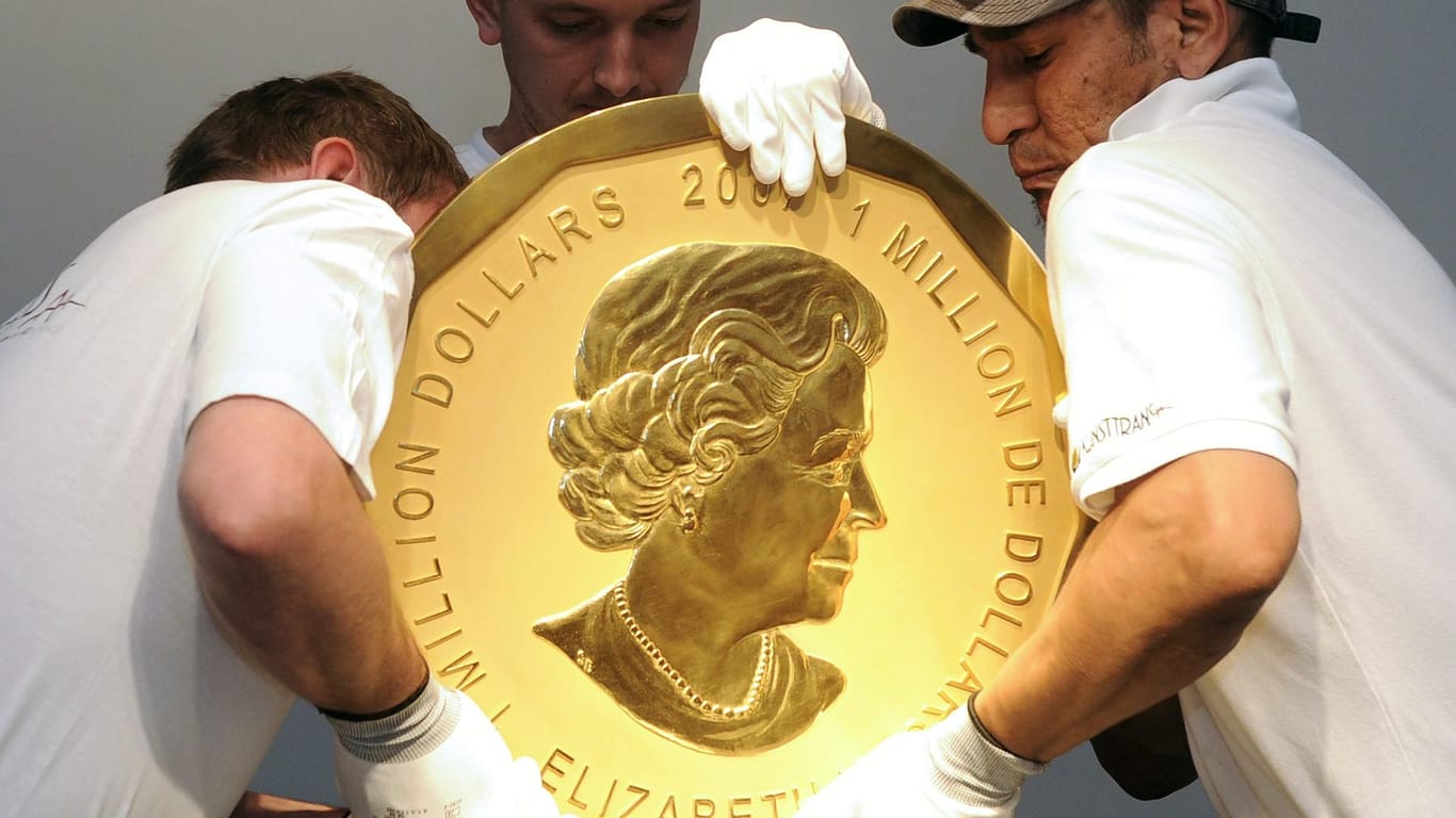 Mitarbeiter eines Auktionshauses in Wien hieven ein Exemplar der "Big Maple Leaf"-Goldmünze an ihren Platz.