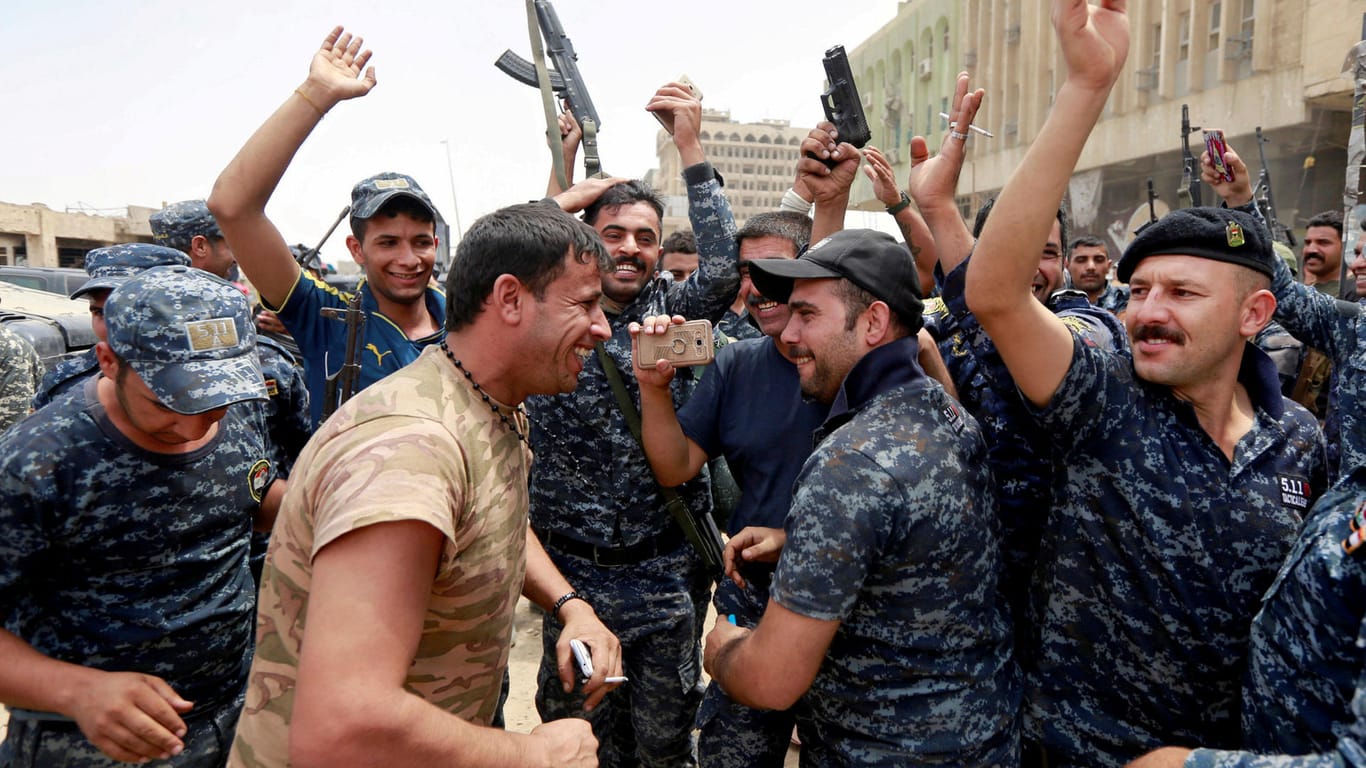 Irakische Polizisten und Militärs feiern in der Altstadt Mossuls den Sieg über den Islamischen Staat.