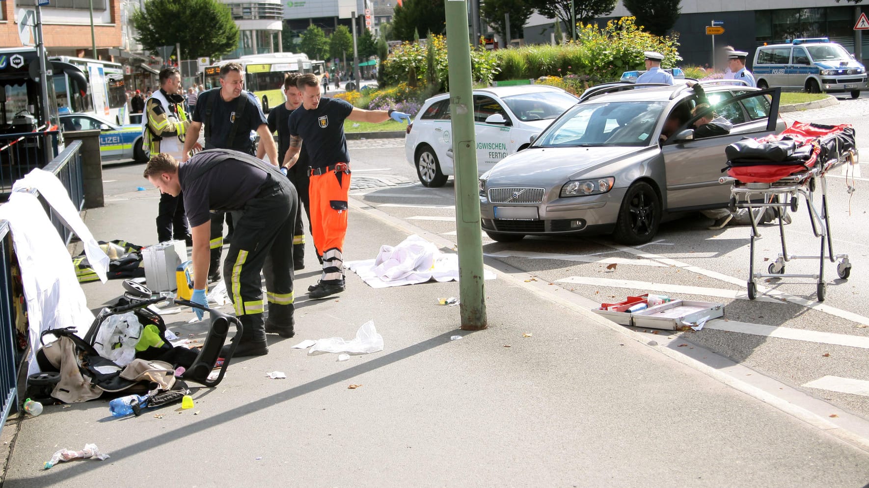 Die Rettungskräfte untersuchen den völlig demolierten Kinderwagen, der auf der Brücke liegt.