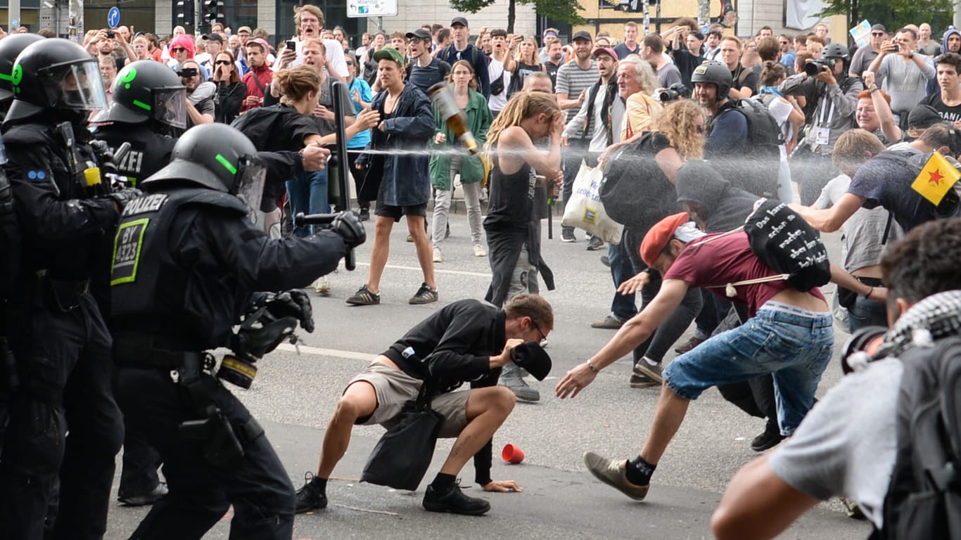 Polizisten setzen Pfefferspray gegen Demonstranten bei G20-Protesten ein.