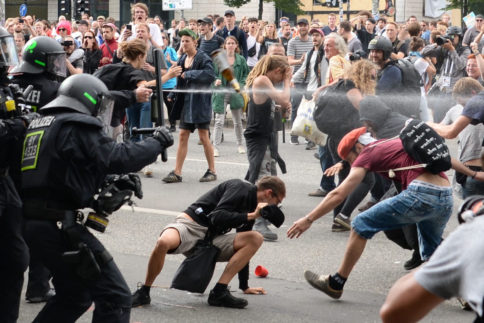Polizisten setzen Pfefferspray gegen Demonstranten bei G20-Protesten ein.