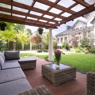 Ein Garten mit überdachter Terrasse: Eine Pergola können Sie einfach, aber auch in der Luxusvariante montieren. (Symolbild)