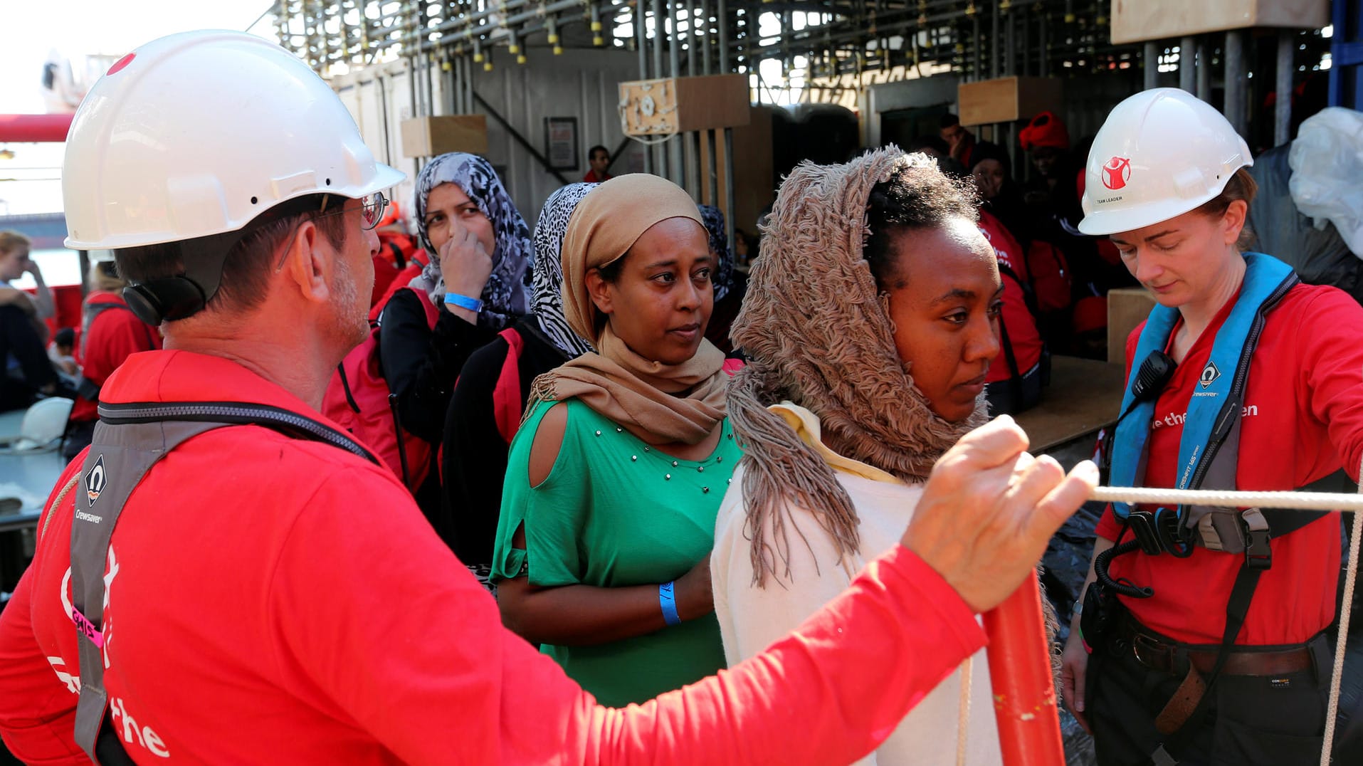Mitarbeiter der Hilfsorganisation "Save the Children" helfen im Mittelmeer geretteten Flüchtlingen von Bord ihres Schiffes. Mitarbeiter der Hilfsorganisation "Save the Children" helfen im Mittelmeer geretteten Flüchtlingen von Bord ihres Schiffes.