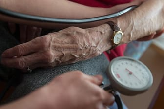 Eine Bewohnerin eines Seniorenheims bekommt den Blutdruck gemessen.