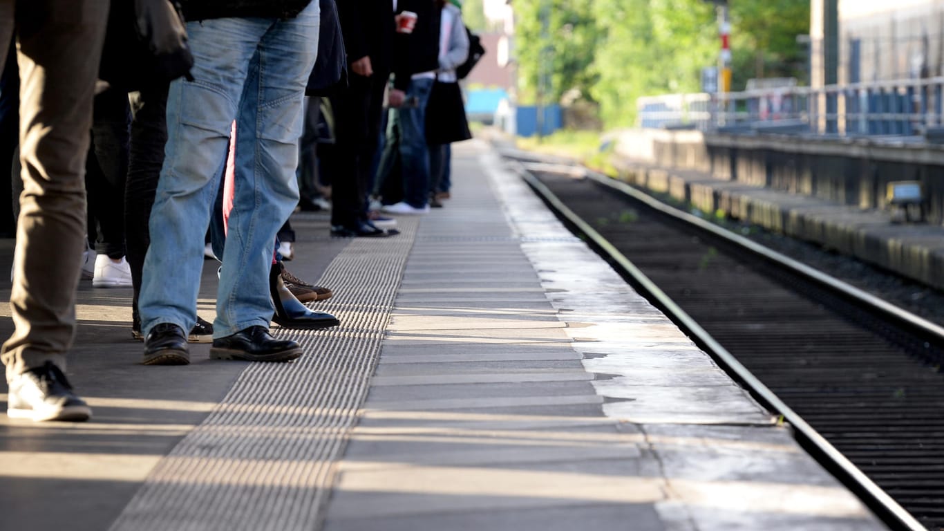 Bahnreisende warten auf einem Bahnsteig (Symbolbild).