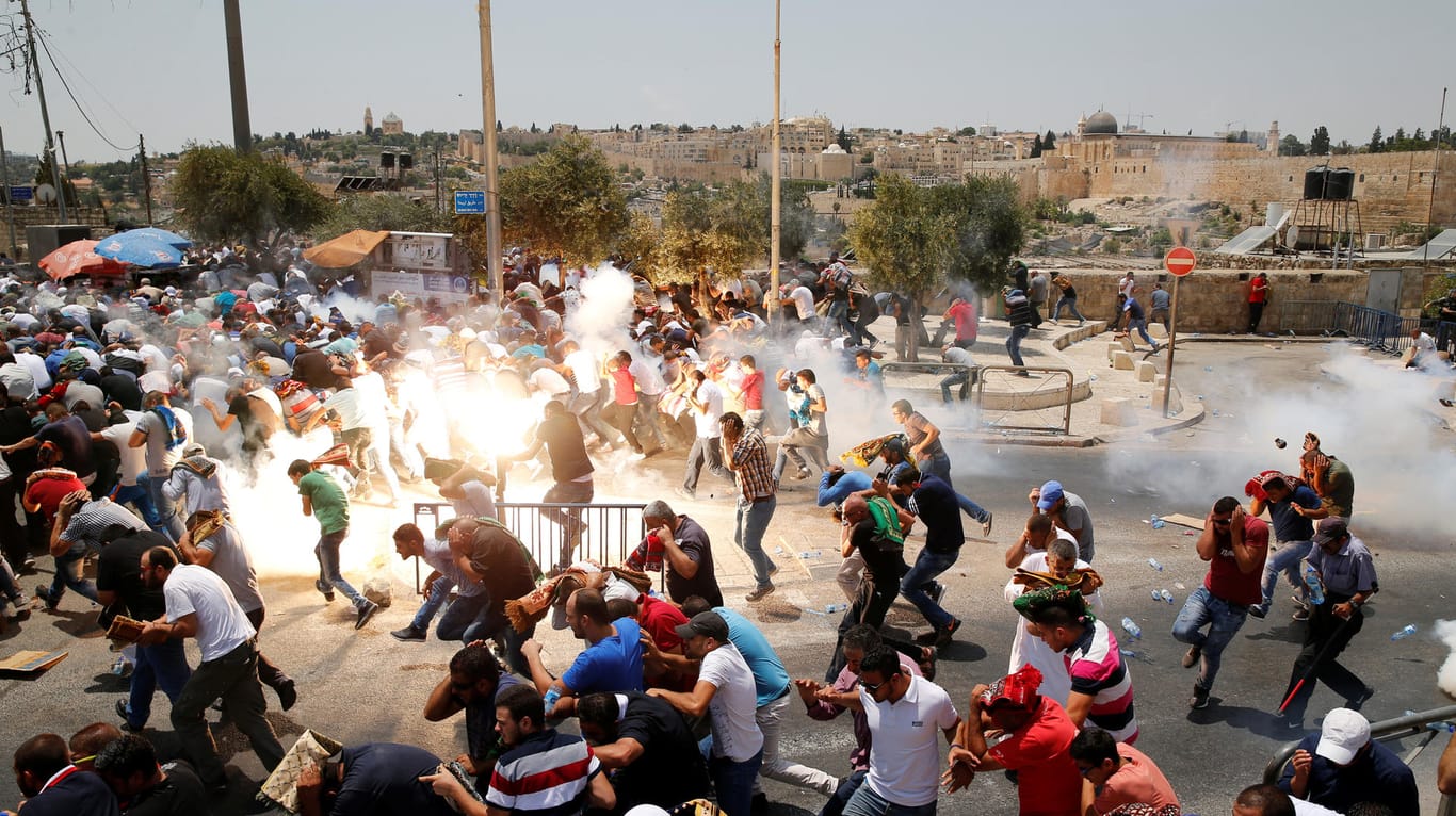 Demonstranten und Randalierer fliehen vor Tränengasgranaten.