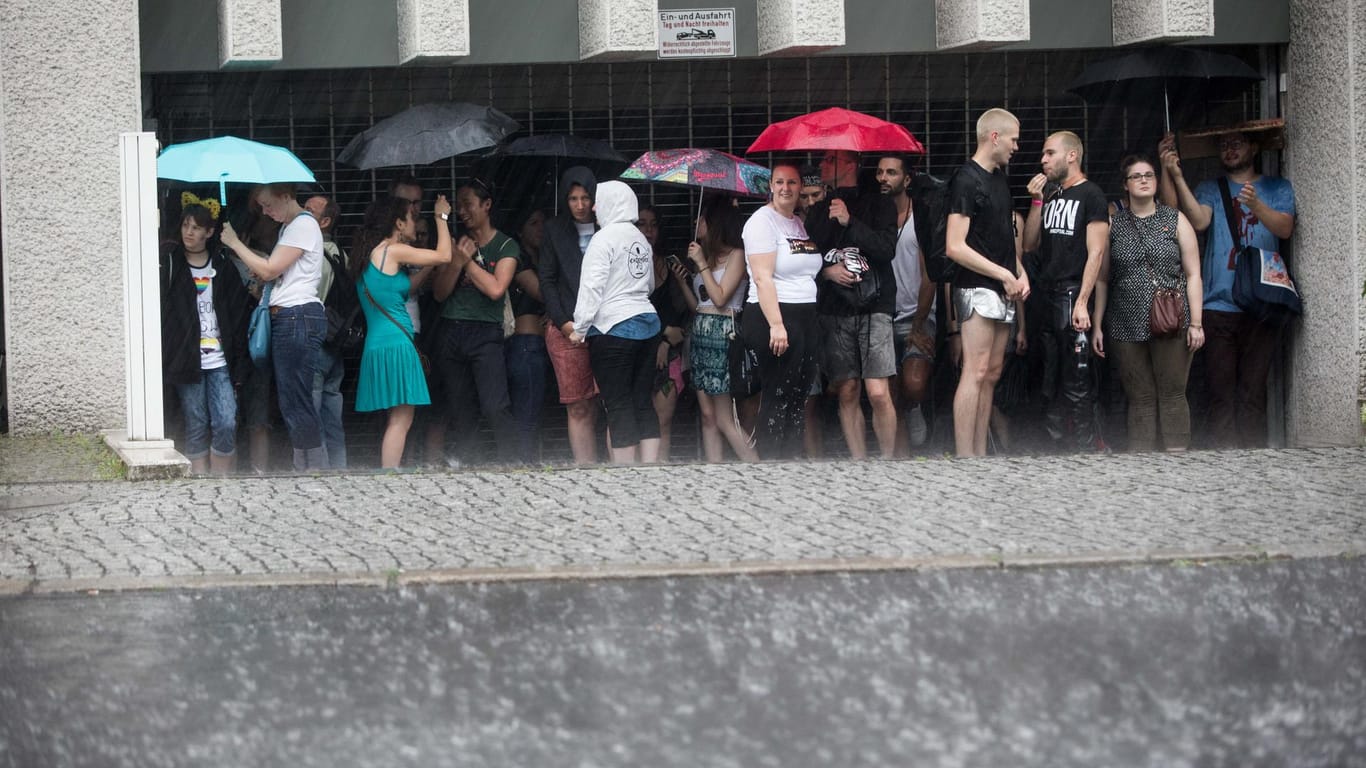 Teilnehmer des Christopher Street Days flüchteten vor dem Starkregen in die Einfahrt einer Tierfgarage.