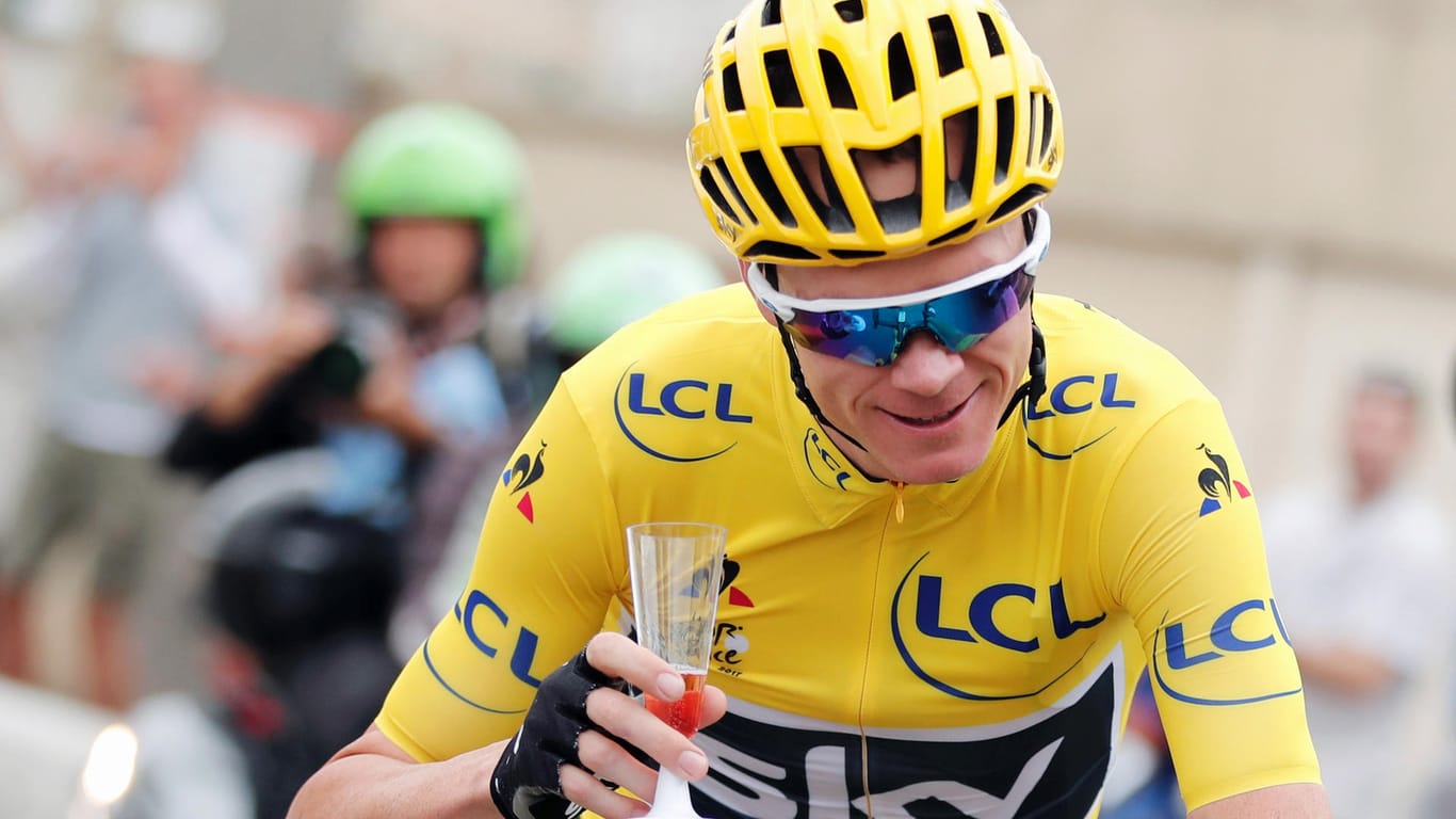 Triumphzug. Christpher Froome mit Sektglas auf der Schlussetappe der Tour de France.