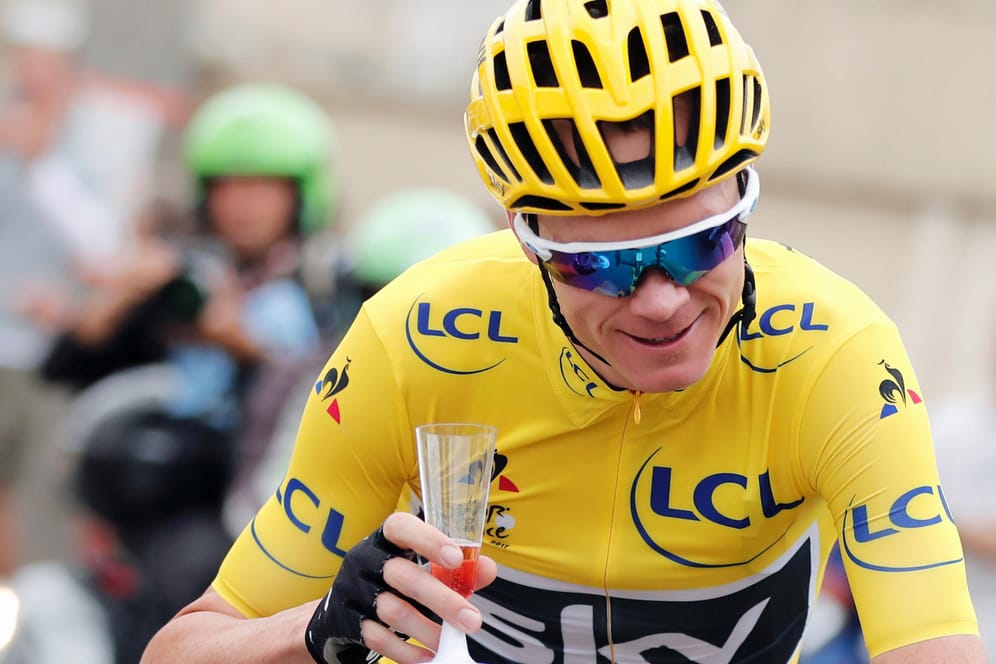 Triumphzug. Christpher Froome mit Sektglas auf der Schlussetappe der Tour de France.