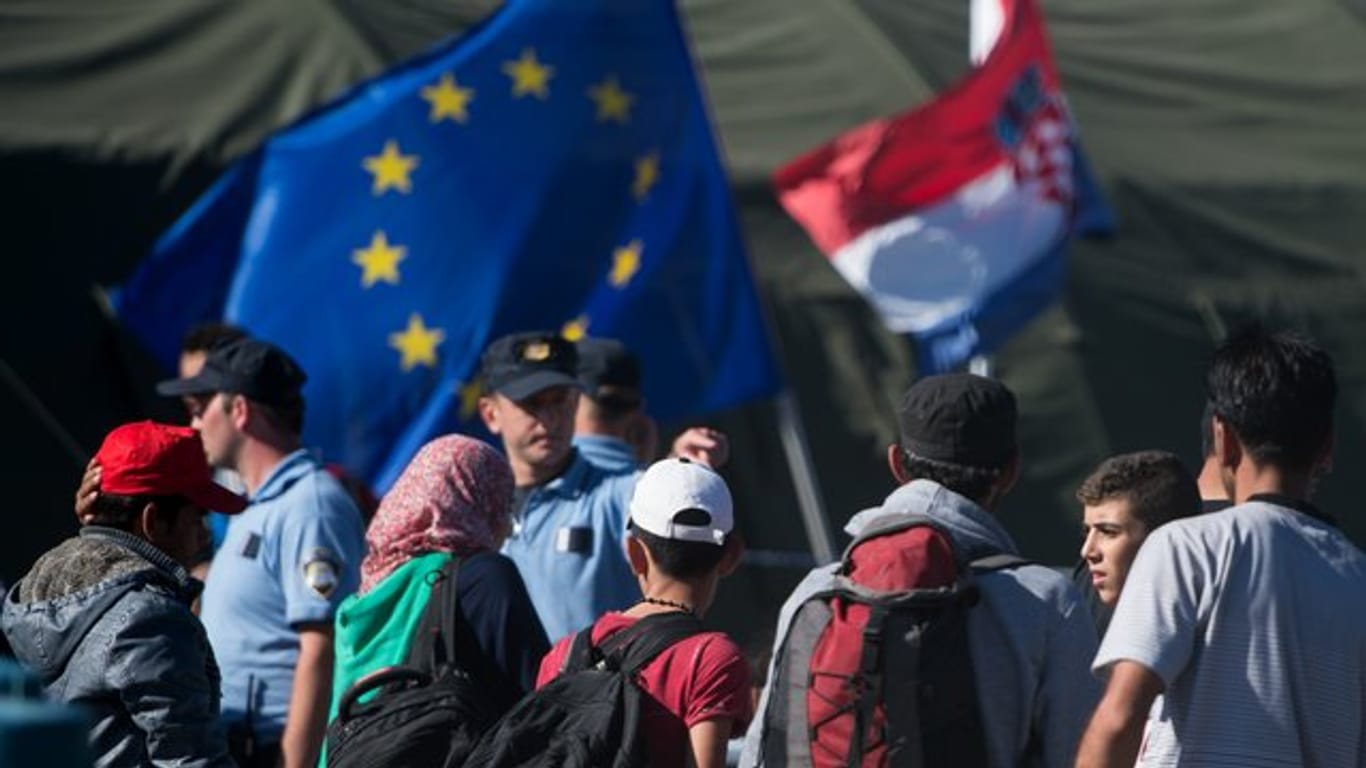 Kroatische Polizisten und Flüchtlinge stehen im September 2015 in einem Zeltlager bei Opatovac.