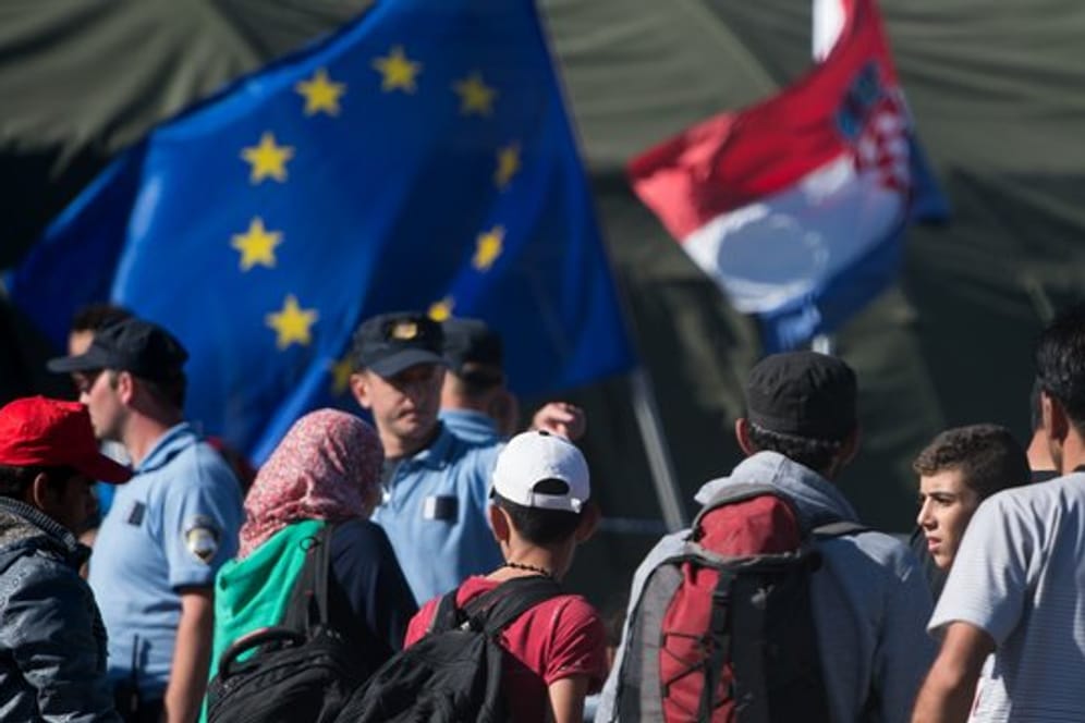 Kroatische Polizisten und Flüchtlinge stehen im September 2015 in einem Zeltlager bei Opatovac.