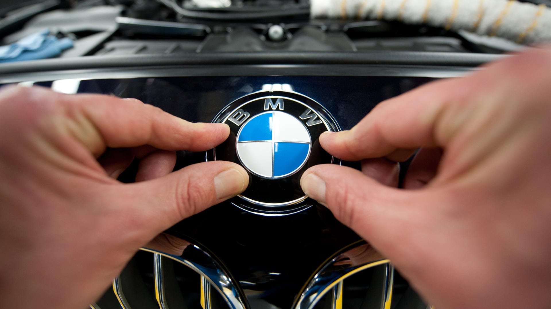 Ein Arbeiter montiert ein BMW-Emblem im Werk Dingolfing.