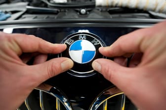 Ein Arbeiter montiert ein BMW-Emblem im Werk Dingolfing.