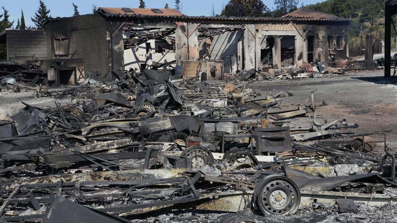 Überreste mehrerer Fahrzeuge und die Ruine eines abgebrannten Supermarktes ist in La Londe-les-Maures (Frankreich) zu sehen.