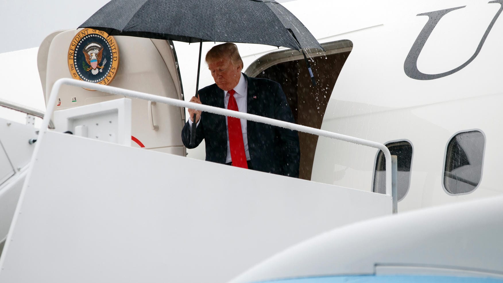 US-Präsident Donald Trump steigt in Andrews Air Force Base (USA) mit einem Regenschirm aus der Air Force One.