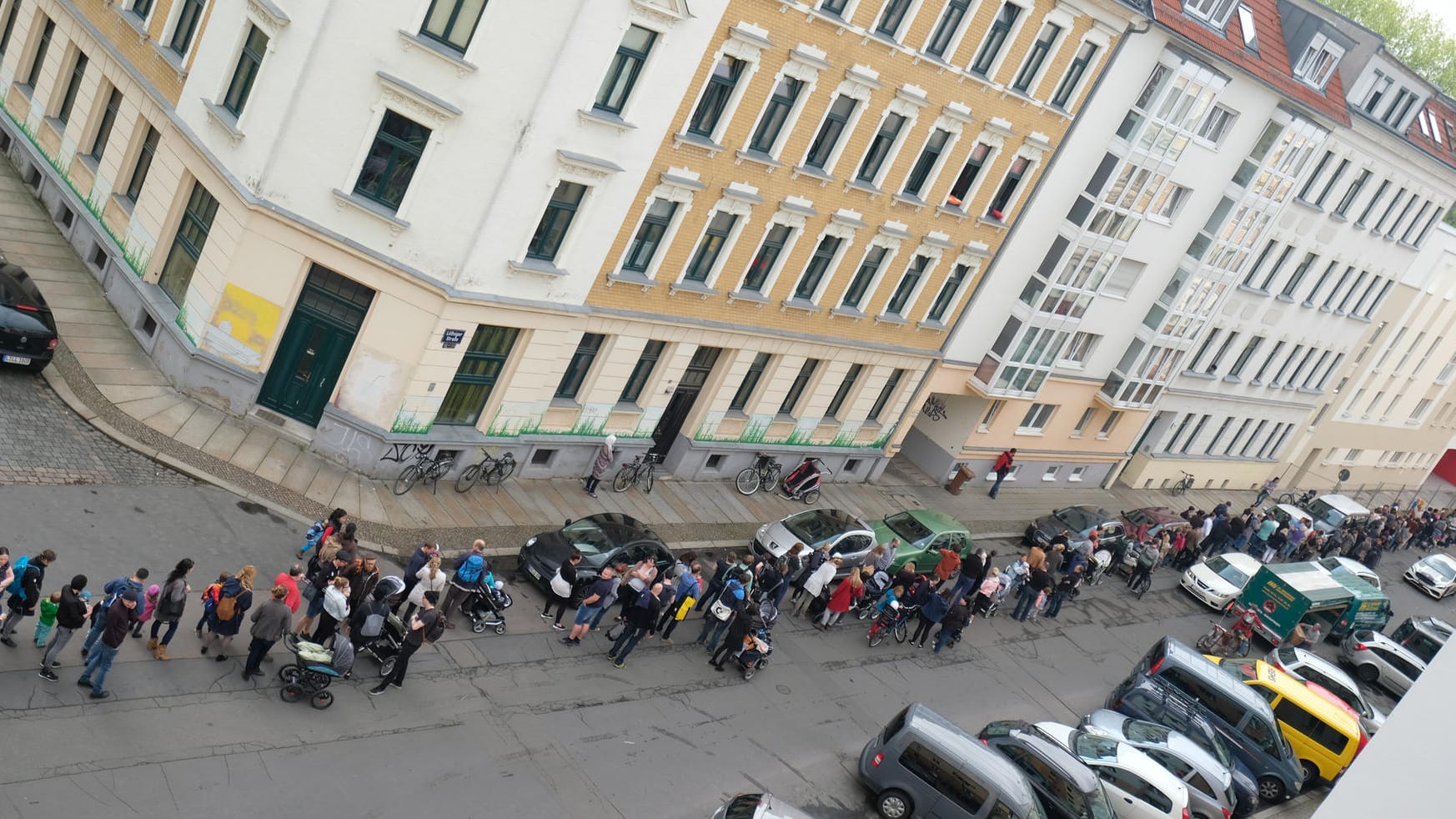 Mehrere hundert Menschen stehen in Leipzig an einer im Bau befindlichen Kindertagesstätte an, um einen Platz für ihr Kind zu bekommen.