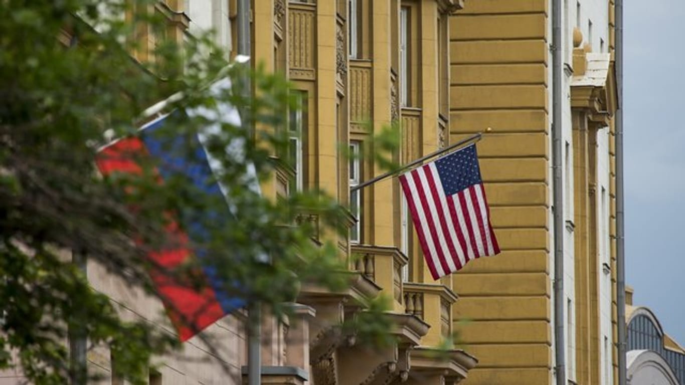 Die Nationalflaggen von Russland (l) und den USA vor der US-Botschaft in Moskau (Russland).
