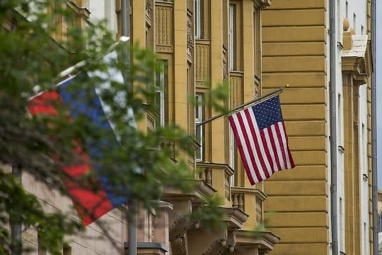 Die Nationalflaggen von Russland (l) und den USA vor der US-Botschaft in Moskau (Russland).