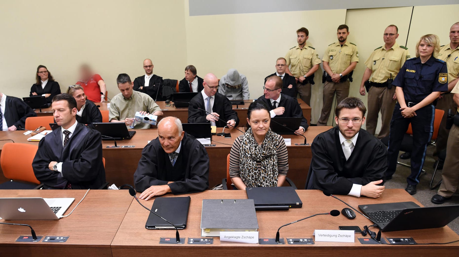 Die angeklagten rechtsextremen "NSU"-Mitglieder Beate Zschäpe (vorne, 2.v.r), Ralf Wohlleben (zweite Reihe, 3.v.l.), Holger G. (rotes Shirt, hintere Reihe) und Carsten S. (grauer Kapuzenpulli) im Gerichtssaal des Oberlandesgerichts München (Archivbild).