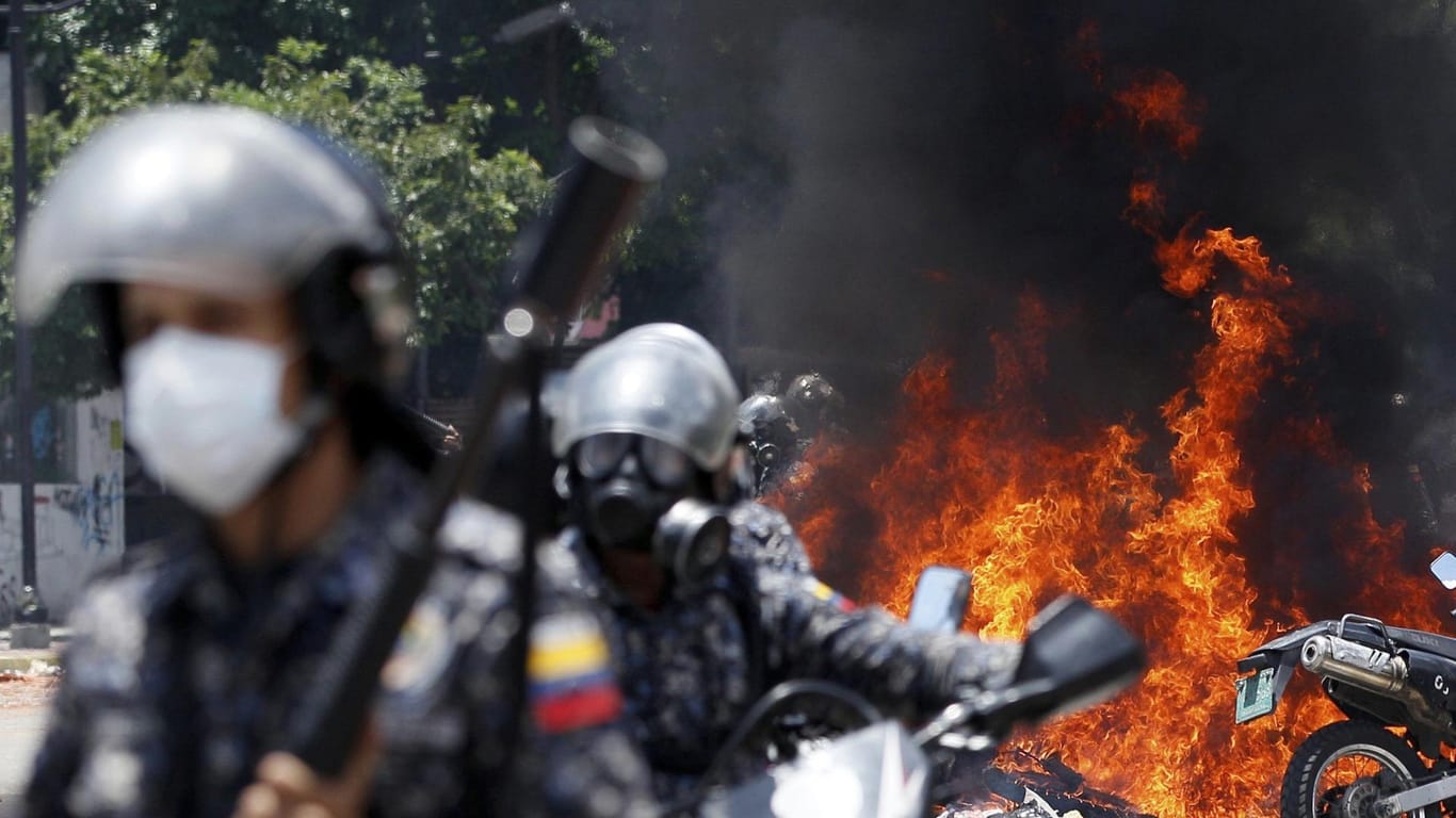 Nach der Explosion eines Sprengkörpers in der Nähe einer Gruppe von Motorradpolizisten zündet die Nationalgarde am 30.07.2017 in Caracas Motorräder der Presse an.