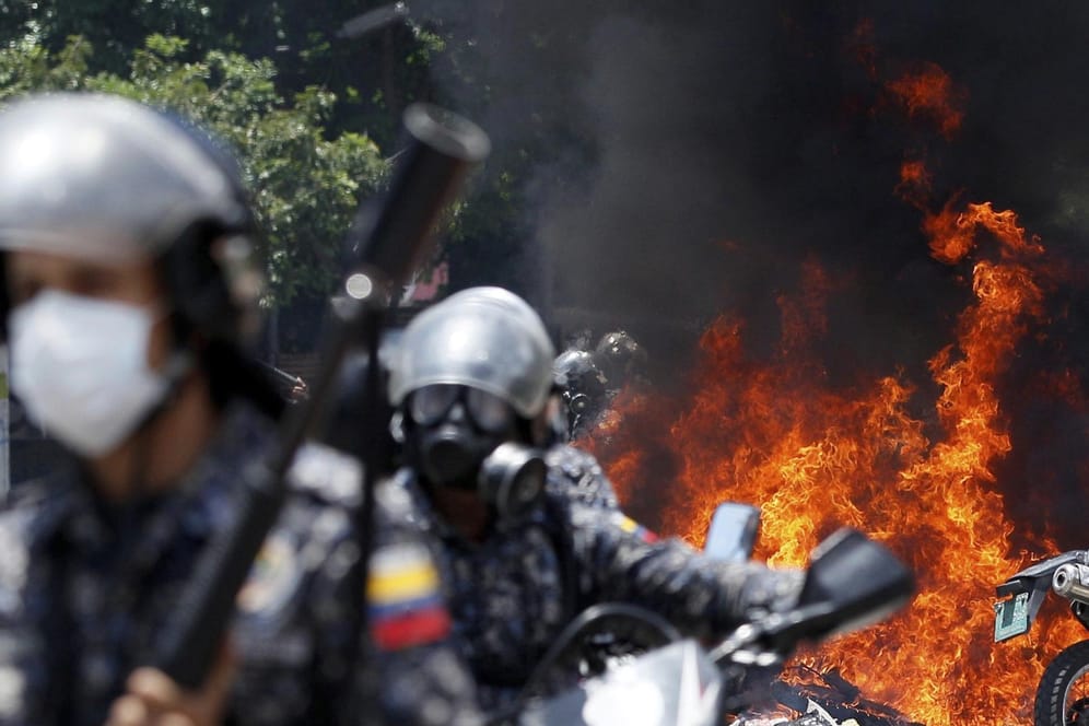 Nach der Explosion eines Sprengkörpers in der Nähe einer Gruppe von Motorradpolizisten zündet die Nationalgarde am 30.07.2017 in Caracas Motorräder der Presse an.