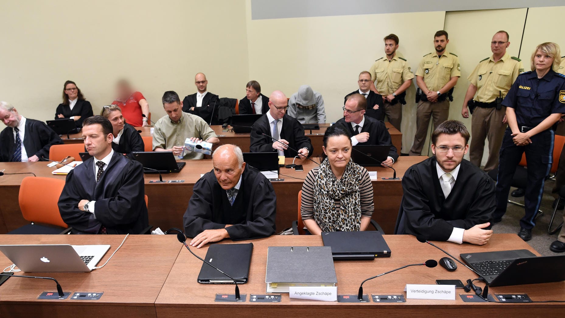 Fortsetzung NSU-PDie angeklagten Beate Zschäpe (vorne, 2.v.r), Ralf Wohlleben (zweite Reihe, 3.v.l.), Holger G. (rotes Shirt, hintere Reihe) und Carsten S. (grauer Kapuzenpulli) im Saal des Oberlandesgerichts München (Archivbild).