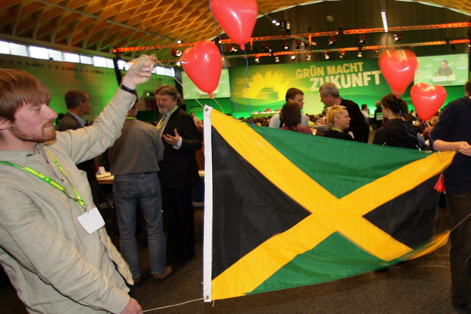 Grüne Anhänger der Jamaika-Koalition halten auf einem Parteitag eine Landesfahne hoch. Derzeit regiert in Schleswig-Holstein eine Landesregierung aus CDU, Grünen und FDP.