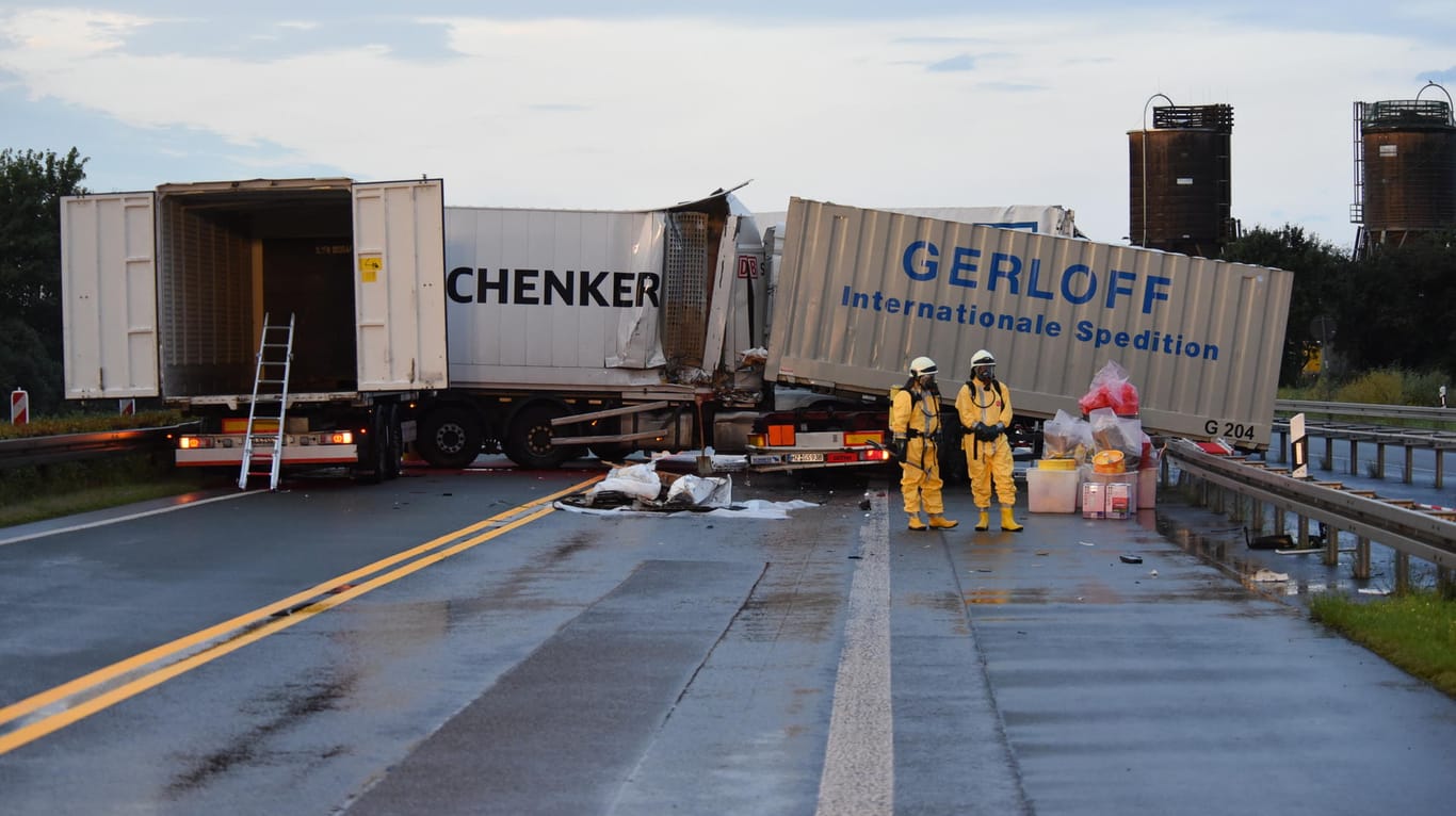 Rettungskräfte in Schutzanzügen sind am 01.08.2017 nach einem Unfall mit einem Gefahrguttransporter auf der Autobahn 5 bei Gießen im Einsatz.