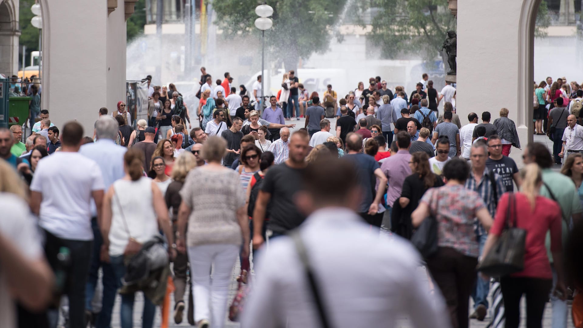 Passanten gehen in München durch die Fußgängerzone.